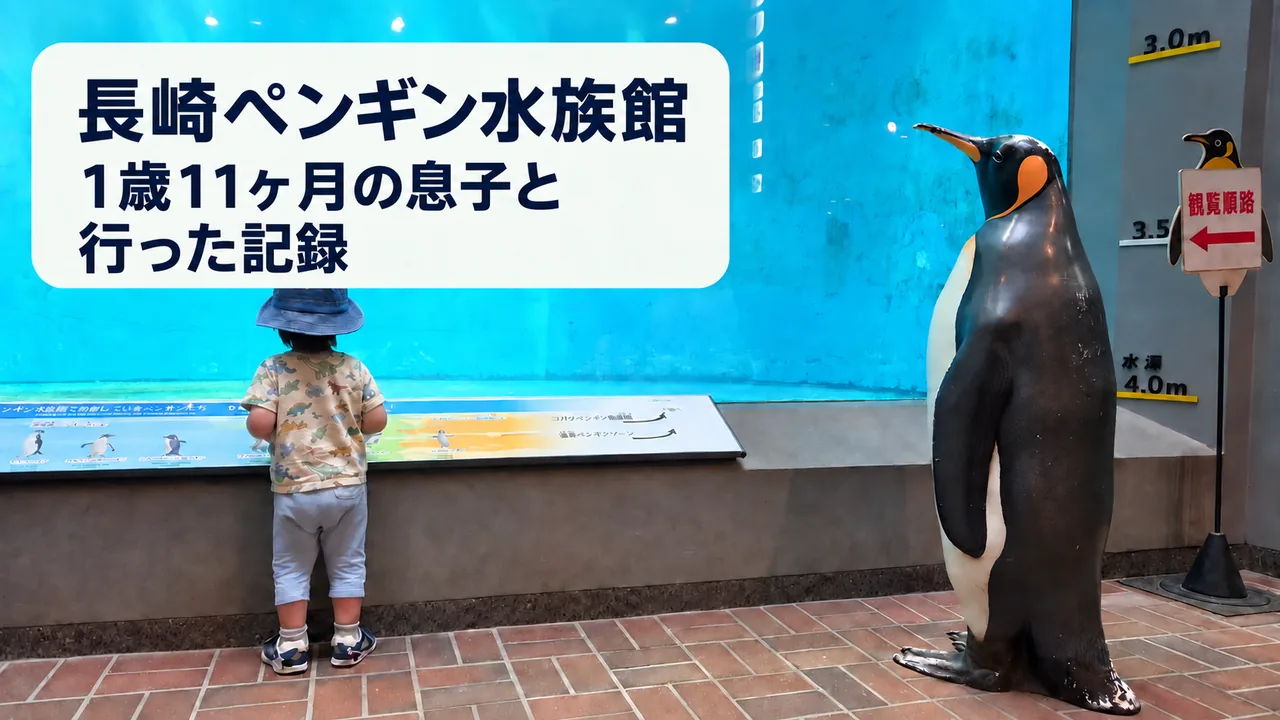 長崎ペンギン水族館の水槽前に立つ1歳11か月の子どもとペンギン模型