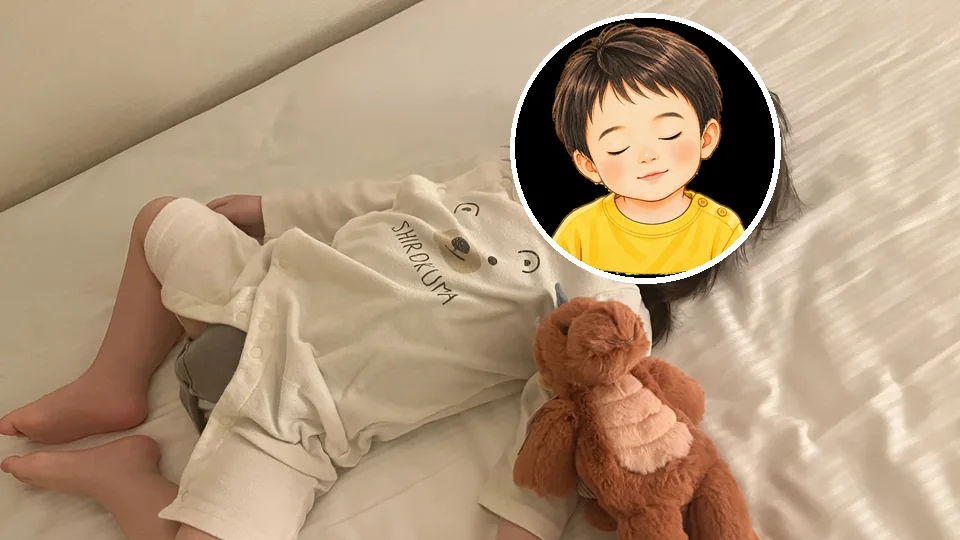 客室のベッドで誕生日プレゼントのぬいぐるみと眠る1歳半の息子