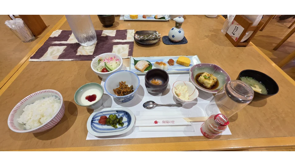 ご飯や汁物、焼き魚、卵焼き、小鉢が並ぶ梅園の里の朝食